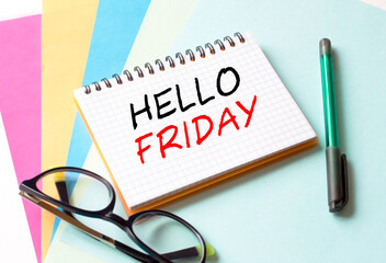 The Notepad with the text Hello Friday is on colored paper with glasses and a pen