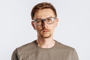 Fototapeta premium Young handsome brunet man with beard wearing glasses frowning and displeased on white isolated background
