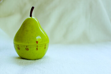 Kitchen egg timer in pear shape turned on 5 minutes isolated on milky background,close up view of kitchen clock for cooking and studying,productivity management and counting time,free place for text