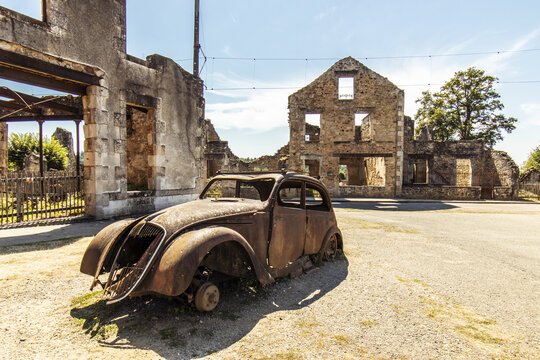 Old car in a ruined street - Oradour sur Glane, French village located in the Haute-Vienne department - martyred village victim of a massacre during the Second World War - historical ruins