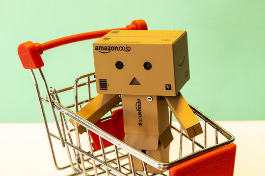 Small Amazon figurine with a supermarket cart on a green background - online store and commerce - promotion, black friday
