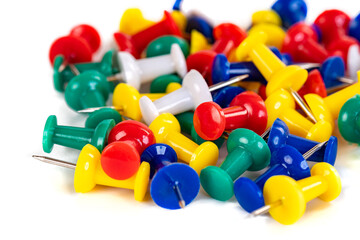 Closeup of Many Colored Thumbtacks on White