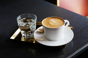 Beautiful serving of coffee, on golden diarrhea in a white paste with eyelash on a flat white foam,