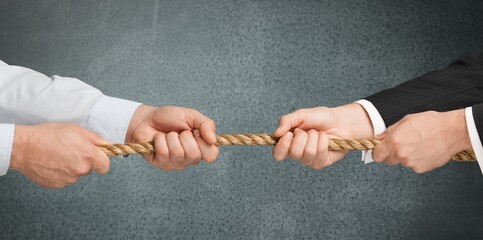 Business people pulling rope in opposite directions