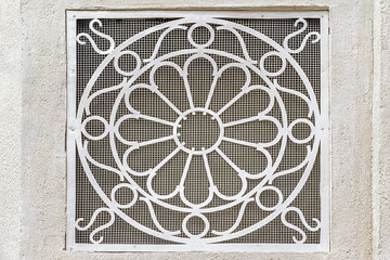 decorative metal ventilation grill in a white wall close up