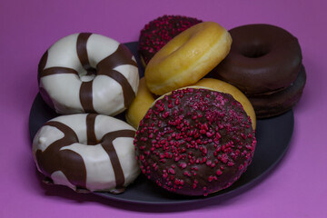 Tasty different kinds of Donuts and Berliner on Pink Background