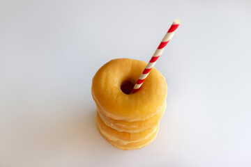 Four Donuts or Classic Donuts Stack and One Red Stripe Straw on a White Background.