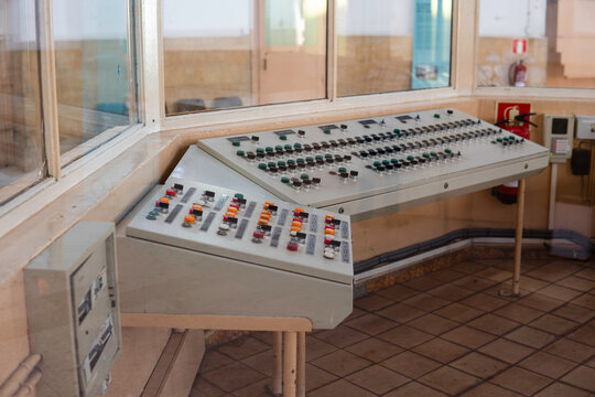 Gray remote сontrol desk with a bunch of buttons in the security room of an old-fashioned prison or jail, controlling the cell doors.