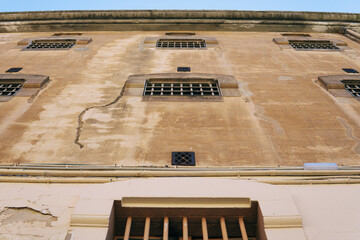 The old prison. Wall of the old prison building. Wall with prison cell windows