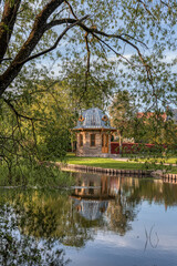 Fototapeta na wymiar garden pavilion among the trees reflecting in the water