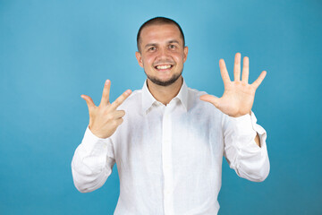 Russian business man over blue background showing and pointing up with fingers number eight while smiling confident and happy.