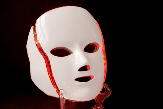 Color therapy mask glowing red, black background