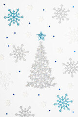 Christmas or New Year's composition 2021. Beautiful xmas tree made of blue and silver decorations on a white background. Greeting card mockup. Flat lay