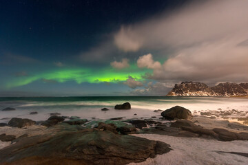 Beautiful Northern Lights in Lofoten Island in Norway. Aurora Boreal over the beach. Majestic green...