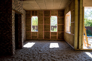 Construction of houses. The walls are made of straw, the internal partitions are made of bricks, the ceiling is made of blocks covered with clay, metal supports.