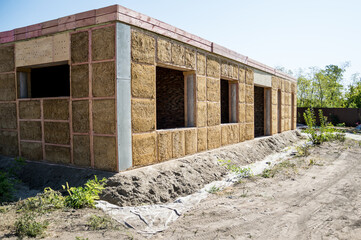 Construction of a house from an environmentally friendly material of plant origin. Frame made of wood, blocks of straw.