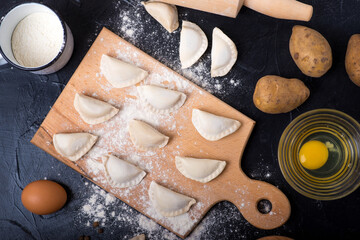 dumplings with mushrooms and ingredients on a dark stone table