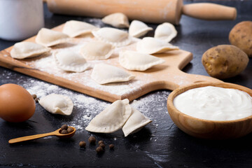 cooking dumplings with potatoes on a dark table