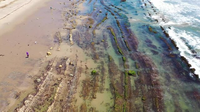 Aerial over people enjoying the beautiful coastline of Santa Barbara, California near Carpinteria bluffs.