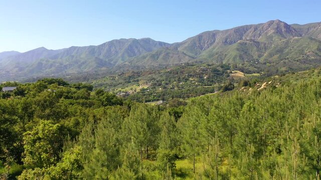 Aerial reveals Carpinteria Montecito California and establishing Santa Barbara mountains above.