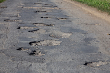 road full of holes in the asphalt. Bumpy.