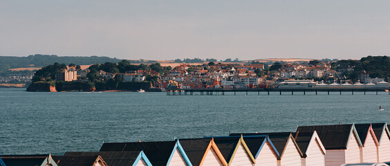 Torquay, Devon, England, UK - Beach huts, the marina and town on a sunny summer day.