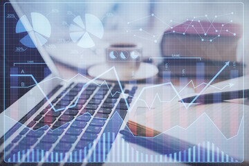 Double exposure of financial chart drawing and desktop with coffee and items on table background. Concept of forex market trading