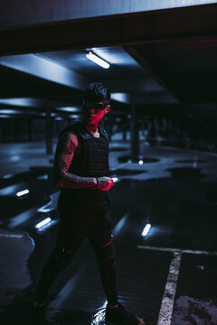 Tattooed man in the night parking lot. Cyberpunk style. Guy with cyber technology.