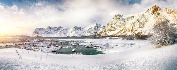 Winter scenery with frozen fjord on Vestvagoy island with snowy  mountain peaks near Valberg