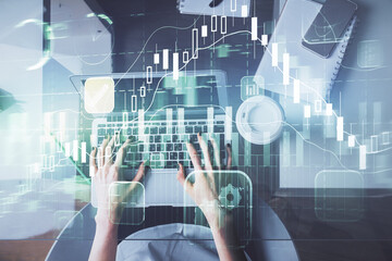 Double exposure of woman hands working on computer and forex chart hologram drawing. Top View. Financial analysis concept.