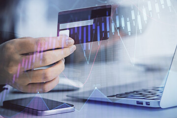 Multi exposure of woman on-line shopping holding a credit card and financial graph drawing. Stock market E-commerce concept.
