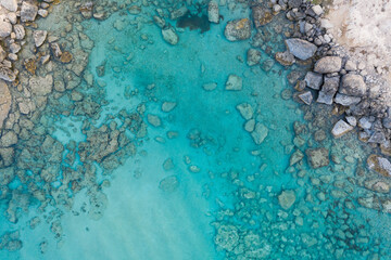 Fototapeta na wymiar An aerial view of the beautiful Mediterranean Sea, where you can see the cracked rocky textured underwater corals and the clean turquoise water of Protaras, Cyprus, 