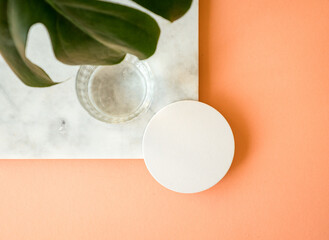 Mock up of a round coaster on a marble board with a glass - obrazy, fototapety, plakaty
