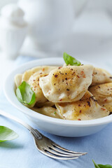 Dumplings with potato and cottage cheese stuffing (pierogi). Traditional Polish Christmas Dinner. Bright background.	