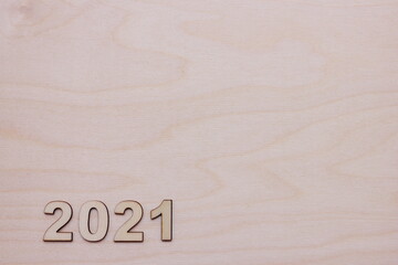 Fototapeta na wymiar New year number 2021 lined with wooden figures on the wooden surface