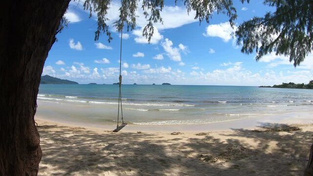Clear sea and white sand beach with swing and sky as background at Koh Chang, Trat, Thailand.