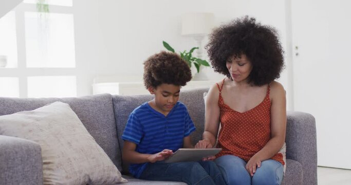 Mother and son using digital tablet at home