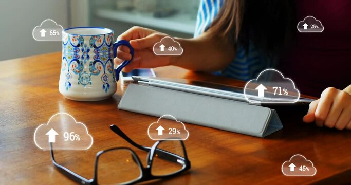 Multiple cloud icons with increasing percentage against mid section of woman using digital tablet