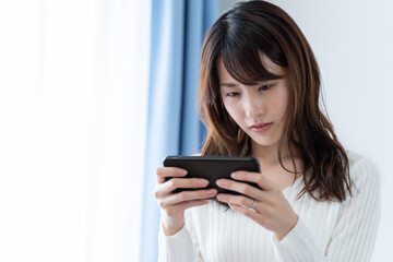 スマートフォンのゲームを楽しむ女性