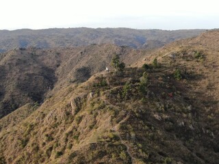 Fototapeta na wymiar Vista aérea panorámica de una cordillera cubierta de árboles. A la derecha se puede apreciar una vista cercana del cerro de la Virgen (1250 metros)