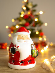 Santa Claus toy on christmas tree and blured lights background.