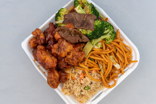 Overhead View Of Chinese Food Ordered From Restaurant For Some Good Mixed Plate Of Mongolian Beef, Rice, Broccoli, And Orange Chicken.