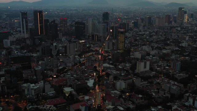 Vista a&eacute;rea panor&aacute;mica de la Glorieta de los Insurgentes y el skyline de Paseo de la Reforma al atardecer.
