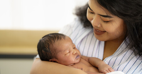 mixed race african american and asian mother holding newborn baby