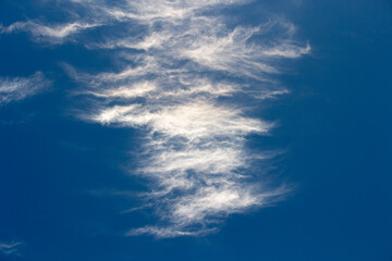 Fototapeta na wymiar High white wispy cirrus clouds with cirro-stratus in the blue Australian sky sometimes called mare's tails indicate fine weather now but stormy changes coming within a couple of days.