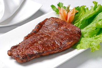 Barbecued sun meat in the white bowl on the table.