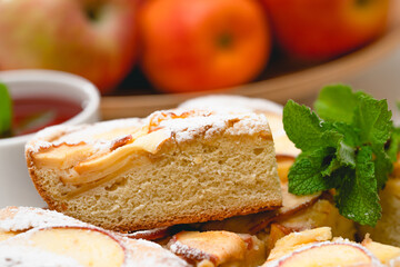 Fresh baked apple pie and cup of herbal tea with mint leaves close up on white background