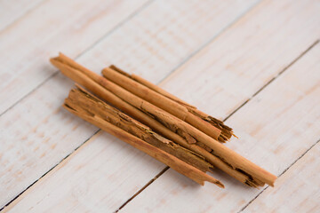 Rajas de canela sobre fondo de madera blanco