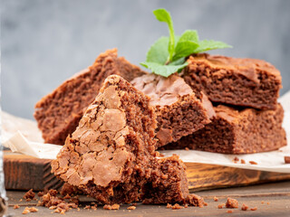 Brownie cookies lie on the board, in the background a glass with milk.