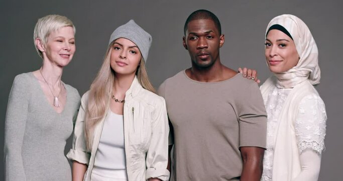 A ethnically diverse group of four people gather together and stare into camera.